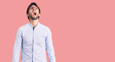 Yakışıklı, iş gömleği giyen, gözlüklü kızgın ve öfkeli sinirli sinirli bağıran, öfkeyle bağıran bir adam. öfke ve agresif konsept. 