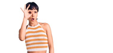 Kısa saçlı, sıradan giyinmiş, güzel jest yapan, şaşırmış yüzüyle, gözleriyle parmaklarından bakan esmer bir kadın. İnançsız ifade. 