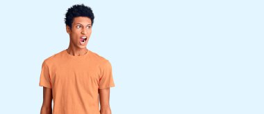 Genç, Afro-Amerikan bir adam, günlük giysiler giymiş kızgın ve kızgın bağırıyor, sinirlenmiş ve öfkeyle bağırıyor. öfke ve agresif konsept. 