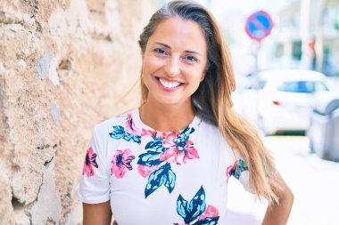 Genç İspanyol kadın gülümseyerek şehirde mutlu mesut duruyor.