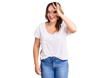 Beyaz günlük tişört giyen genç, güzel beyaz bir kadın. El hareketleriyle gülümsüyor, gözleriyle mutlu yüzüyle parmaklarının arasından bakıyor.. 