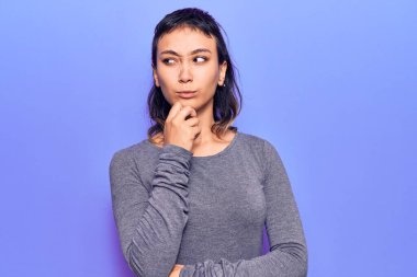 Gündelik kıyafetler giyen genç bir kadın şüphe üzerine yoğunlaşmıştı. Parmakları çenesinde ve yukarı bakıyordu. 