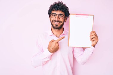 Kıvırcık saçlı yakışıklı genç bir adam ve elinde boş alanı olan bir pano tutan bir ayı. 