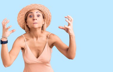 Yazlık şapkalı genç bir kadın öfkeyle bağırıyor, elleri boğazlamaya çalışıyor, deli gibi bağırıyor. 