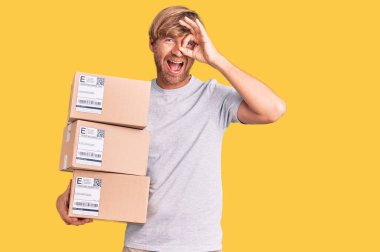 Sakallı yakışıklı beyaz adam teslimat paketleri taşıyor. Gülümsüyor. Tamam. 