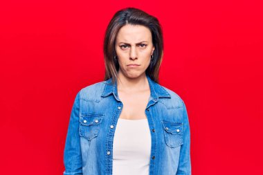 Gündelik kıyafetler giyen, kuşkucu ve gergin genç ve güzel bir kadın sorun yüzünden üzgün. negatif kişi. 