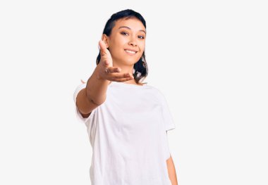 Günlük kıyafetler giyen genç bir kadın gülümseyerek selamlama ve hoş geldin demek için tokalaşmayı teklif ediyor. başarılı iş. 