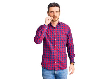 Ayılı yakışıklı genç bir adam. Günlük gömlekler giyiyor. Ağzı ve dudakları parmakları fermuar gibi kapalı. gizli ve sessiz, tabu konuşması 