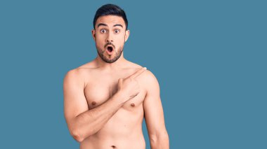 Mayo giyen genç ve yakışıklı bir adam parmaklarını yana doğru göstererek şaşırdı, ağzı açık hayret içinde kaldı.. 