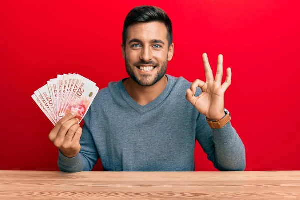 Hombre Hispano Guapo Sosteniendo Shekels Israel Haciendo Signo Con Los —  Fotos de Stock