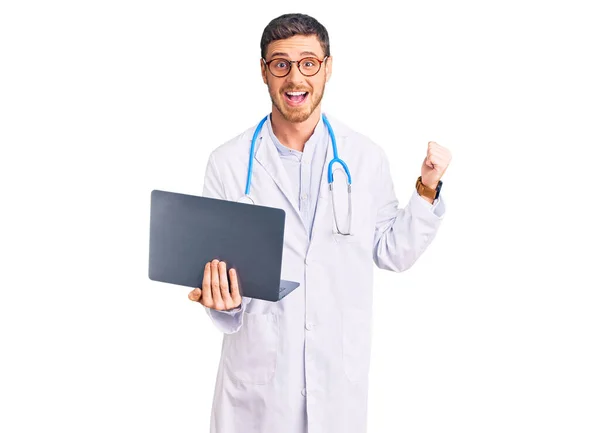 Przystojny Młody Człowiek Mundurze Lekarza Pracujący Komputerowym Laptopem Krzycząc Dumny — Zdjęcie stockowe