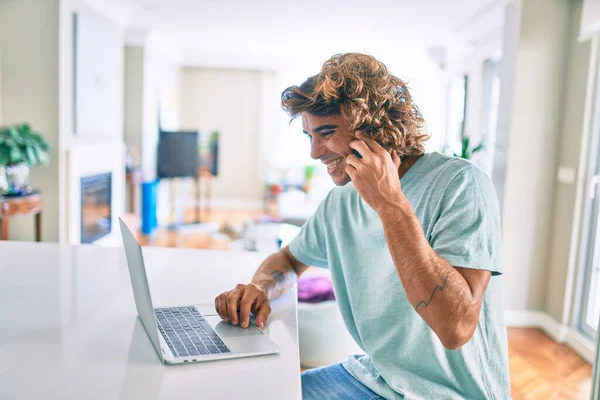 Genç Spanyol Adam Evde Akıllı Telefon Dizüstü Bilgisayar Kullanıyor — Stok fotoğraf