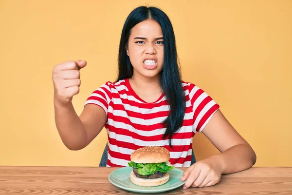 Fiatal Ázsiai Lány Eszik Egy Ízletes Klasszikus Hamburger Bosszús Frusztrált — Stock Fotó