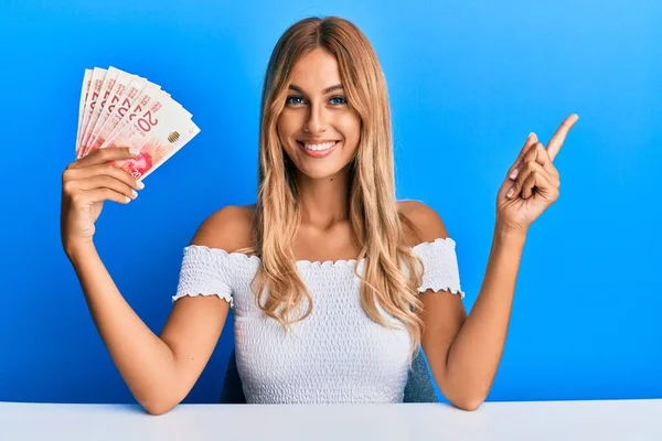 Hermosa Joven Rubia Sosteniendo Billetes Shekels Israelel Sonriendo Feliz Señalando — Foto de Stock