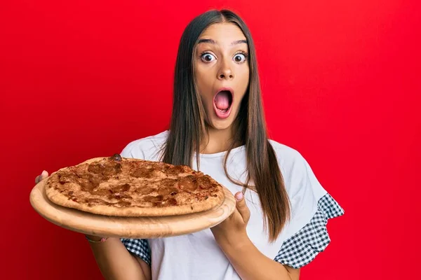 Ung Latinamerikansk Kvinna Håller Italiensk Pizza Firar Galen Och Förvånad — Stockfoto