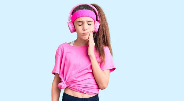 Linda Niña Hispana Usando Ropa Gimnasio Usando Auriculares Tocando Boca —  Fotos de Stock