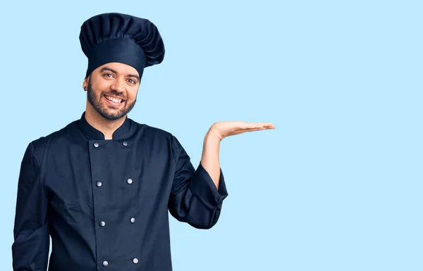 Νεαρός Ισπανός Που Φοράει Στολή Μάγειρα Χαμογελώντας Χαρούμενα Παρουσιάζοντας Και — Φωτογραφία Αρχείου