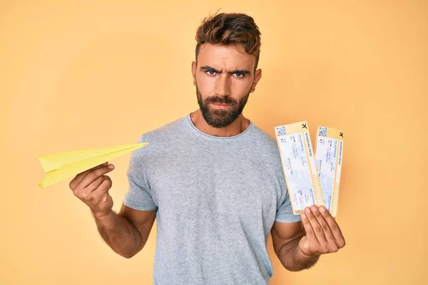 Joven Hispano Sosteniendo Avión Papel Abordando Tarjeta Escéptico Nervioso Frunciendo —  Fotos de Stock