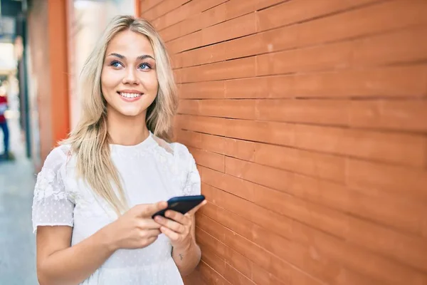 Joven Chica Caucásica Sonriendo Feliz Usando Teléfono Inteligente Apoyado Pared — Foto de Stock