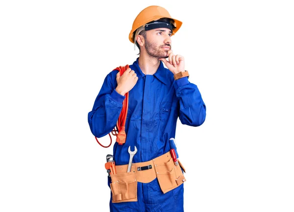 Joven Hombre Hispano Con Uniforme Elecriciano Sosteniendo Cable Cara Seria — Foto de Stock