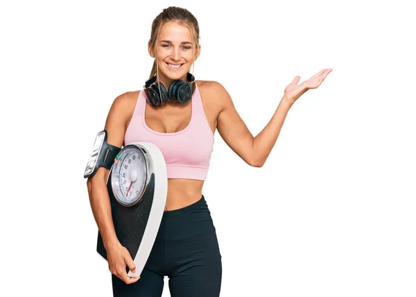 Jonge Blonde Vrouw Dragen Sportkleding Holding Weegmachine Vieren Overwinning Met — Stockfoto