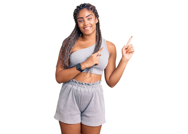 Młoda Afroamerykanka Warkoczami Odzieży Sportowej Uśmiechnięta Patrząca Kamerę Dwiema Rękami — Zdjęcie stockowe