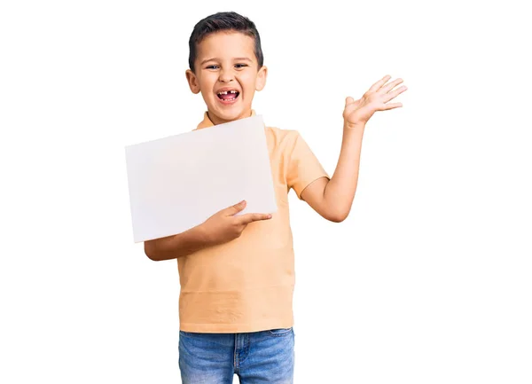 可爱的小男孩举着空白的纸板横幅 带着快乐的笑容和高举双手庆祝胜利 — 图库照片