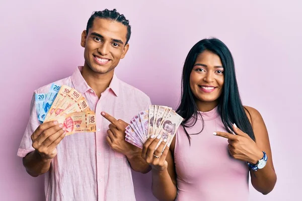 Jovem Casal Latino Segurando Pesos Mexicanos Sorrindo Feliz Apontando Com — Fotografia de Stock