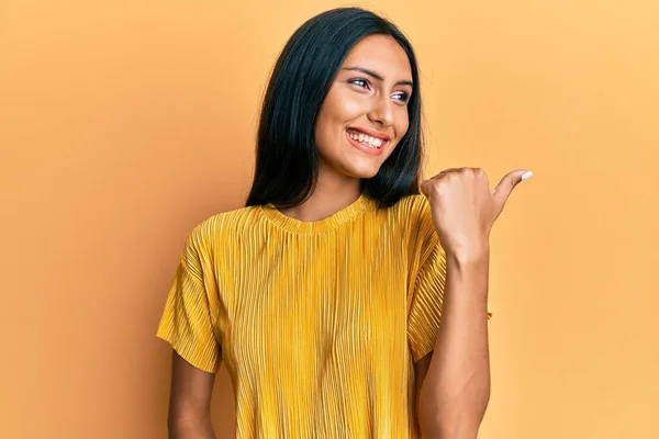 Joven Morena Vistiendo Camiseta Amarilla Sobre Fondo Amarillo Apuntando Pulgar — Foto de Stock