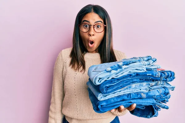 Jong Latin Meisje Holding Stack Van Gevouwen Jeans Bang Verbaasd — Stockfoto