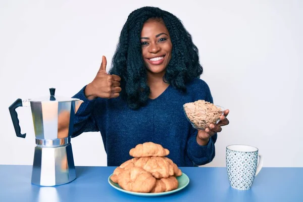 Piękna Afrykańska Kobieta Siedzi Stole Jedząc Płatki Śniadaniowe Uśmiechnięta Szczęśliwy — Zdjęcie stockowe