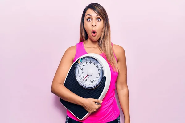 Young Beautiful Woman Holding Weighing Machine Scared Amazed Open Mouth — Stock Photo, Image