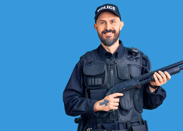 Jovem Homem Bonito Vestindo Uniforme Policial Segurando Espingarda Olhando Positivo — Fotografia de Stock