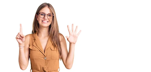 Young beautiful blonde woman wearing casual clothes and glasses showing and pointing up with fingers number six while smiling confident and happy.