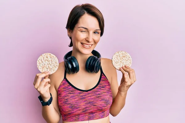 Young Brunette Woman Short Hair Wearing Sportswear Holding Rice Cakes — Stock Photo, Image