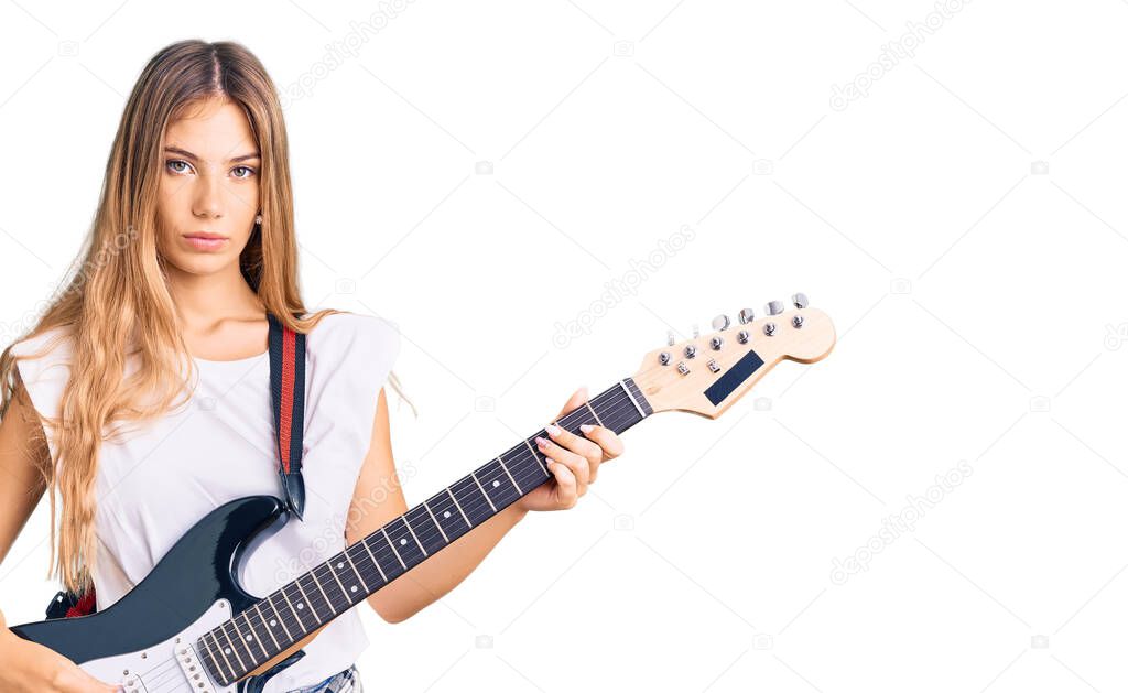 Beautiful caucasian woman with blonde hair playing electric guitar thinking attitude and sober expression looking self confident 