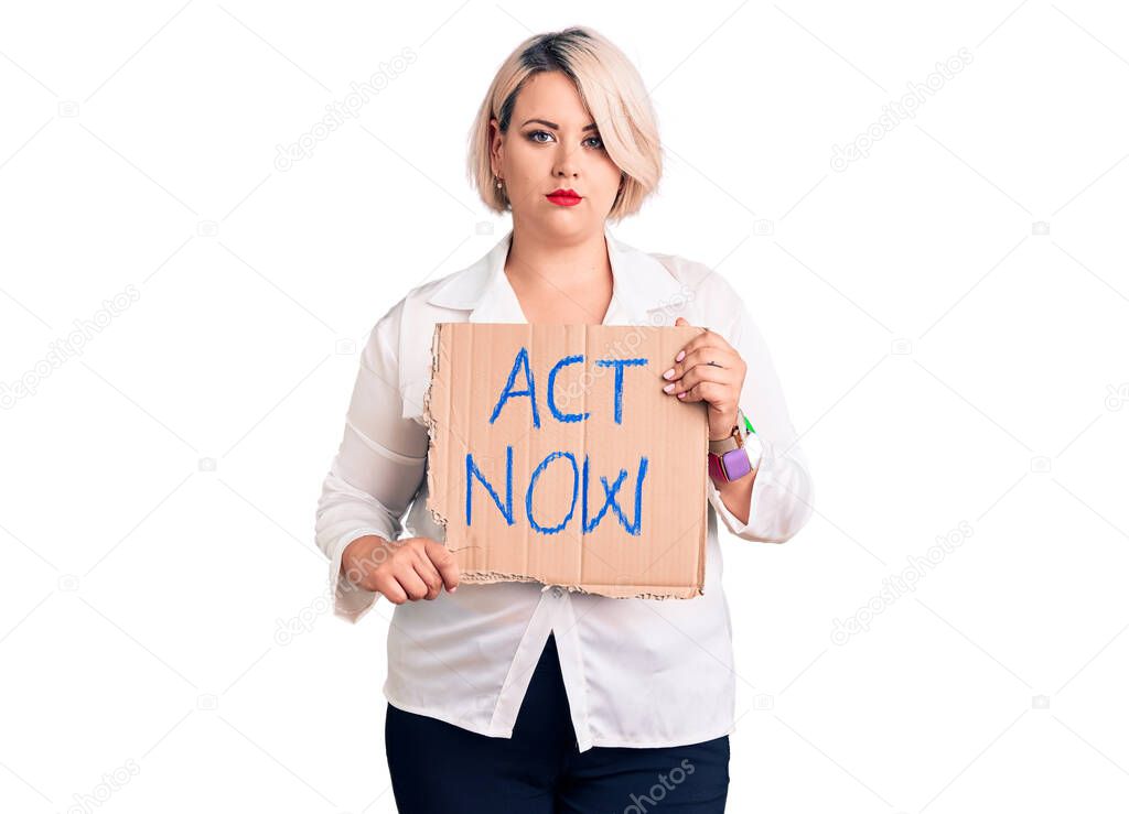 Young blonde plus size woman holding act now cardboard banner thinking attitude and sober expression looking self confident 