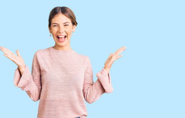 Sarışın, güzel, beyaz bir kadın. Sıradan bir kazak giyiyor. Zaferi kutluyor. 