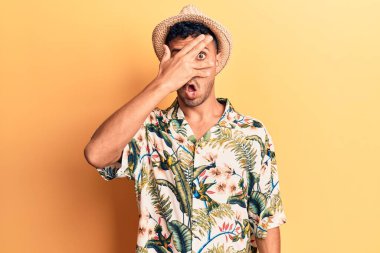 İspanyol asıllı genç adam, yaz şapkası takıyor. Şoka giriyor, yüzünü ve gözlerini eliyle kapatıyor. Korkuyla parmaklarından bakıyor. 