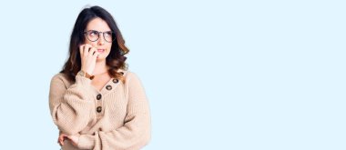 Güzel, genç, esmer bir kadın. Günlük kıyafetler ve gözlük takıyor. Stresli ve gergin görünüyor. anksiyete. 