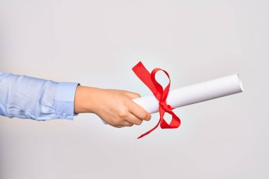 Beyaz arka planda diploma almış beyaz tenli beyaz bir kadının eli.