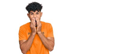 Mutluluk mesajı içeren tişört giyen genç Arap adam kıkırdıyor, gülüyor, kıkırdıyor ağızlarını ellerle, dedikodularla ve skandal konseptiyle kapatıyor. 