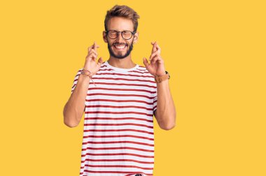 Sakallı, sıradan kıyafetler giyen ve gözlük takan yakışıklı sarışın. Umut ve gözler kapalı gülümseyerek el sallıyor. Şans ve batıl inançlar. 