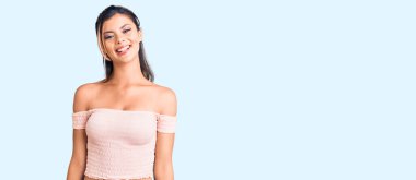 Yüzünde mutlu ve havalı bir gülümseme olan sıradan kıyafetler giyen genç ve güzel bir kadın. şanslı kişi. 