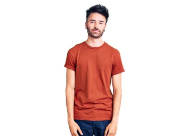 Yüzünde ciddi bir ifade olan günlük kıyafetler giyen genç bir İspanyol. Basit ve doğal bir şekilde kameraya bakıyorsun.. 