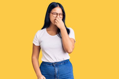 Genç, güzel Asyalı bir kız günlük kıyafetler ve gözlük takıyor. Kokuşmuş ve iğrenç bir koku alıyor. Dayanılmaz bir koku. Kötü kokuyor. 