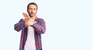 Genç, yakışıklı, sıradan kıyafetler giyen, reddedilen, kollarını kavuşturan, negatif işaretler yapan, kızgın yüzlü bir adam. 