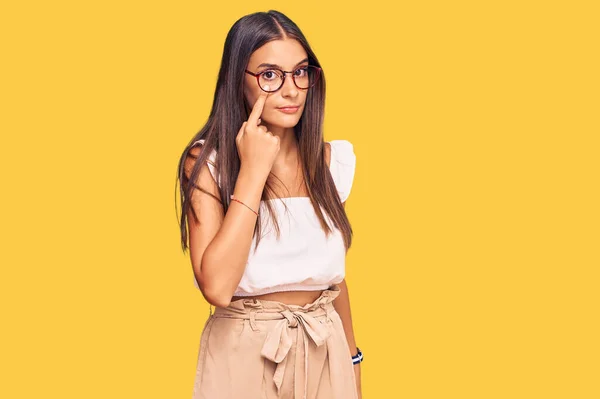若いヒスパニック系の女性がカジュアルな服や眼鏡をかけてあなたのジェスチャーを見て 疑わしい表現を指す — ストック写真
