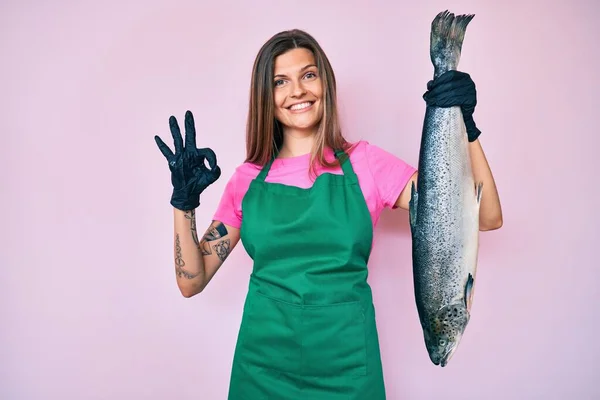 Beautiful Caucasian Woman Fishmonger Selling Fresh Raw Salmon Doing Sign — Stock Photo, Image