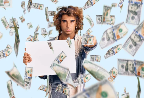 Elinde boş pankart tutan genç İspanyol adam kamerayı işaret ediyor ve sen kendine güvenen ciddi bir hareket yapıyorsun.